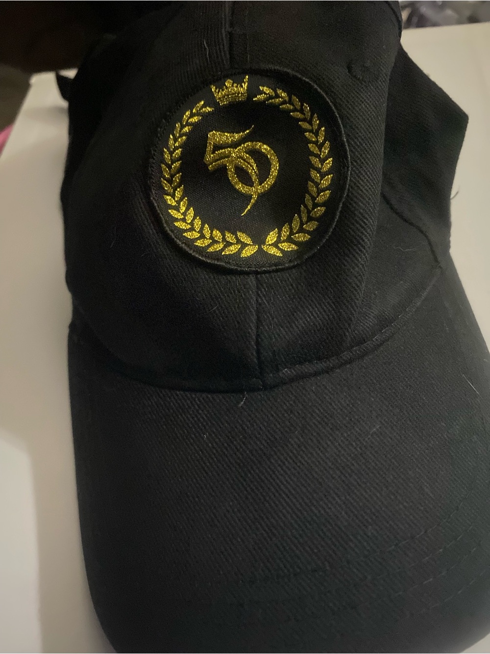 Source Unknown Black Cap with Gold Laurel Emblem